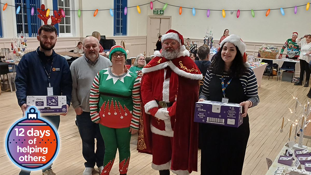 A group of people with Santa in a community hall