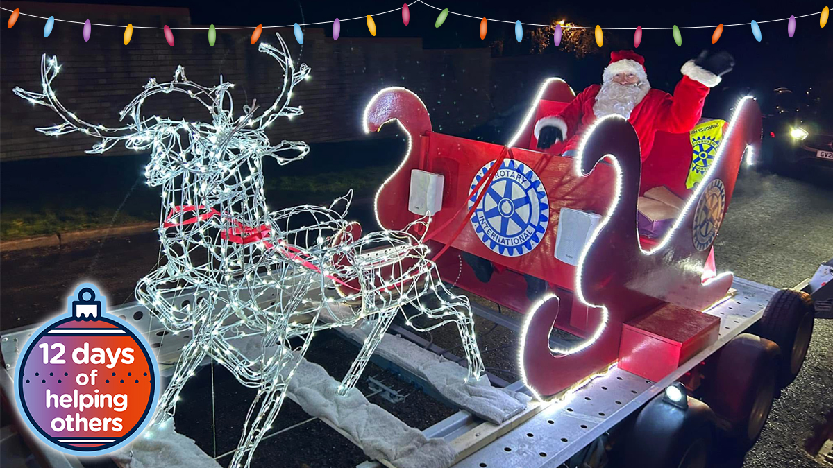 Santa in his sleigh being pulled by wireframe reindeer with fairy lights on