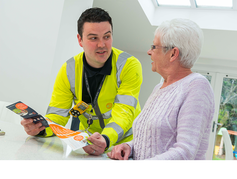 An engineer showing an SGN leaflet to a customer