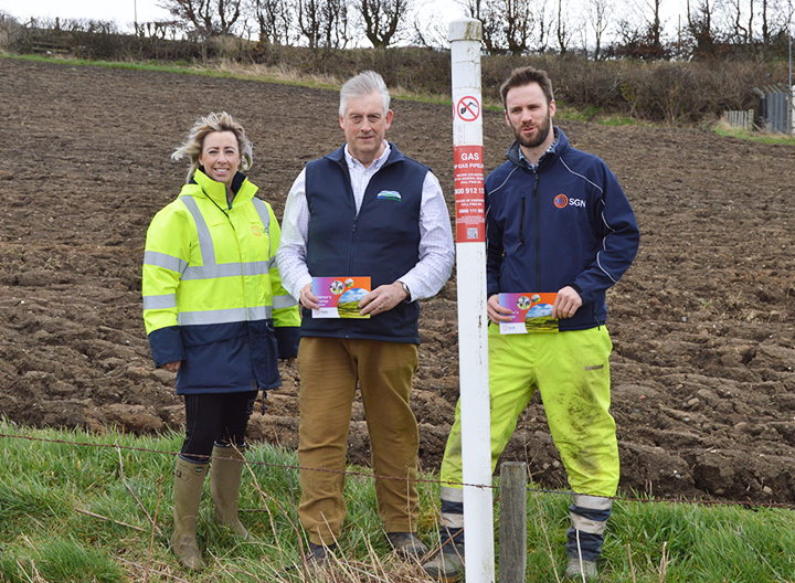 SGN colleagues with NFU Scotland partners standing in field next to pipeline location marker