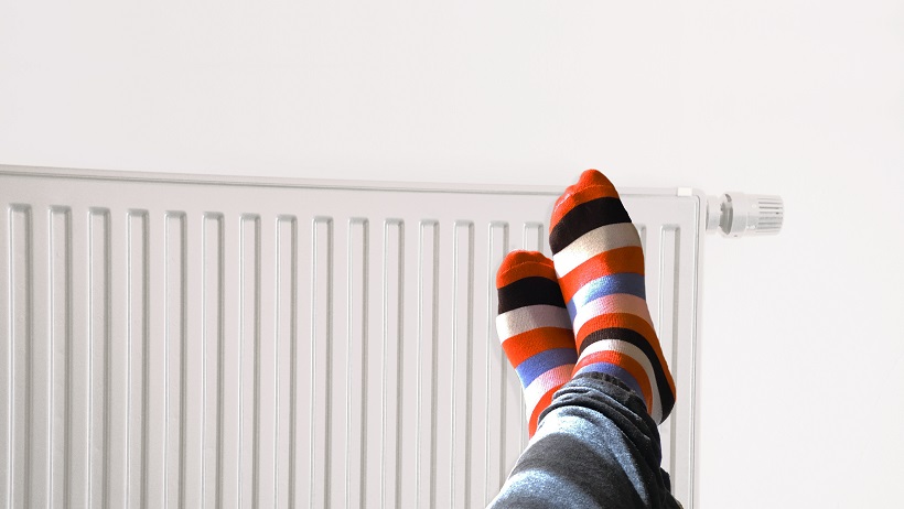 Feet wearing stripy socks resting on a warm radiator