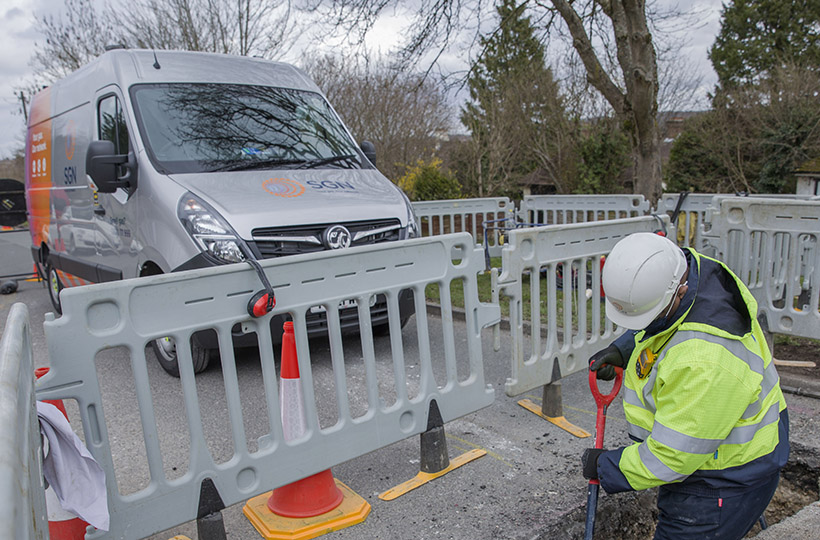 Image of SGN engineer digging hole on street with SGN van in background