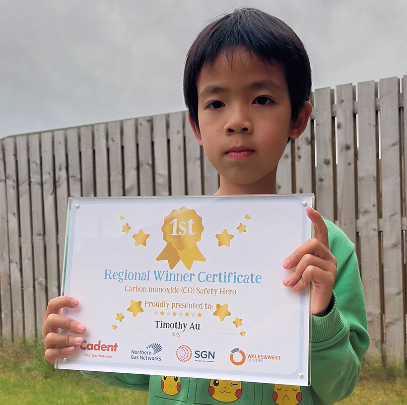 A child holding their certificate for winning our carbon monoxide competition