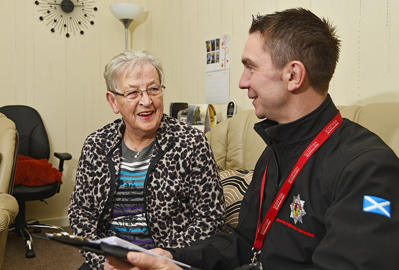 SFRS man giving home safety advice to elderly customer