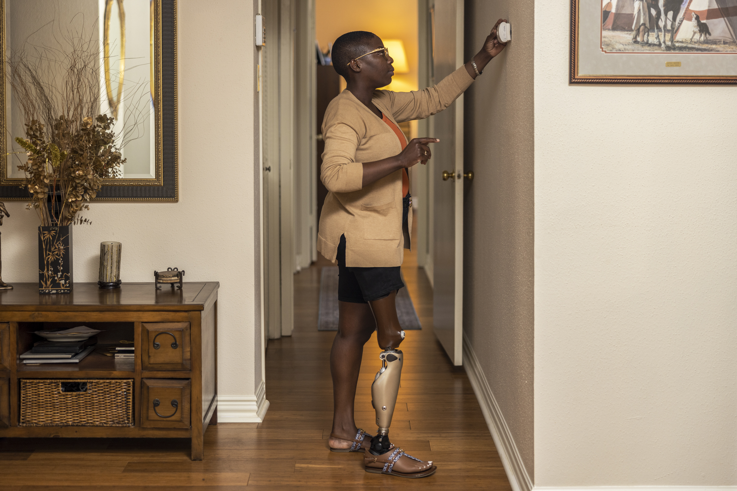 A black woman with a prosthetic leg adjusting her thermometer