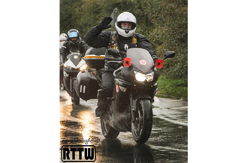 A man riding a motorbike in rainy conditions with other motorbikes behind