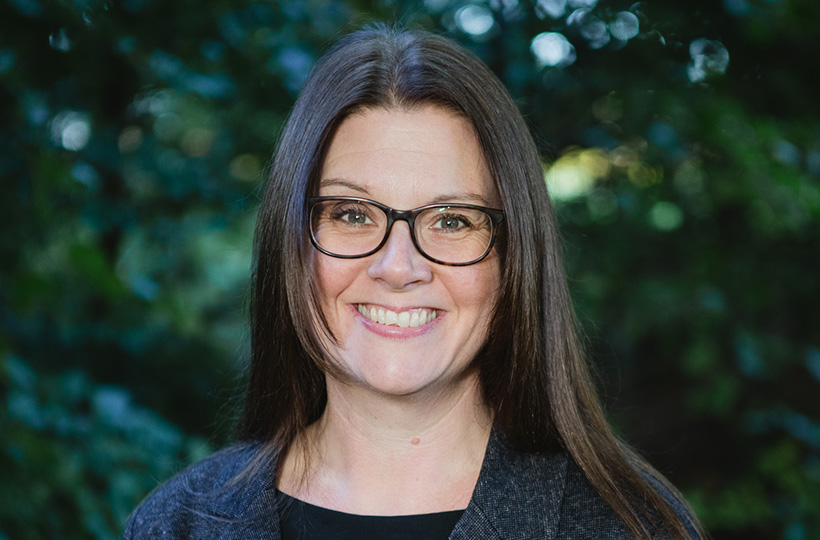 A smiling person wearing glasses