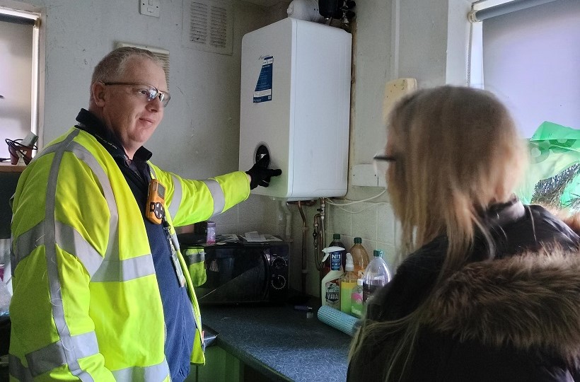 An SGN engineers talks to a female customer while checking her boiler during loss of supply incident in Herne Bay January 2025