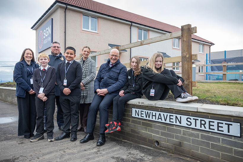 A group of people in front of homes