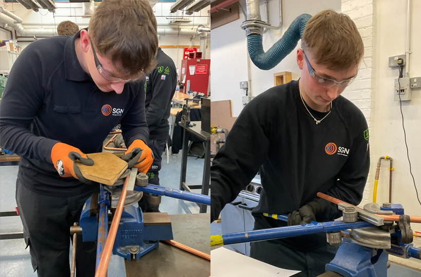 Two apprentices working with tools to bend metal gas pipes