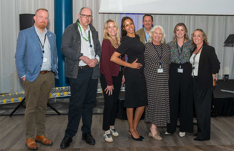Eight men and women smiling to the camera, all chairs of SGN's employee networks