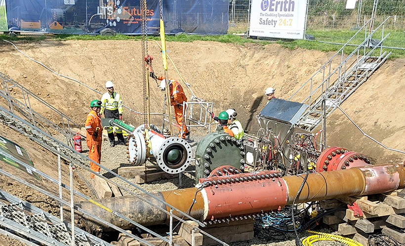 A group of engineers working on large LTS pipe in an excavation