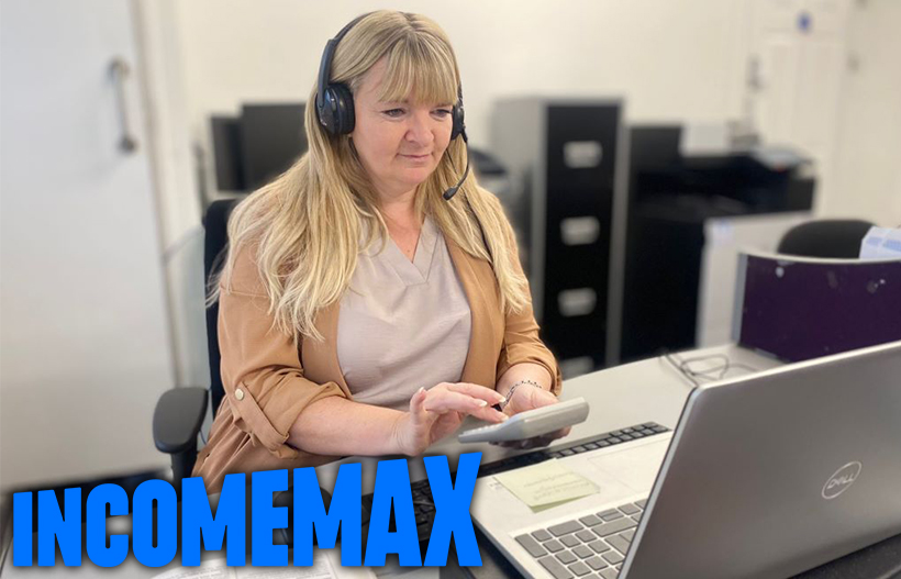 A woman wearing a headset using a calculator and laptop
