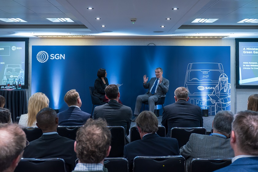 Minister for Energy Security and Net Zero Dr Alan Whitehead CBE and SGN's Abbie Sampson speak on stage in front of delegates at event dedicated to accelerating biomethane growth