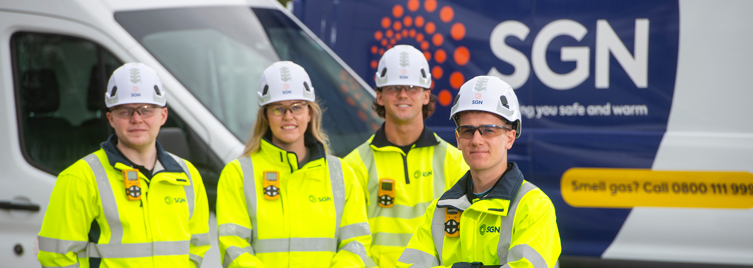 A team of four SGN engineers standing in full PPE. There are three men and one women. They are smiling.