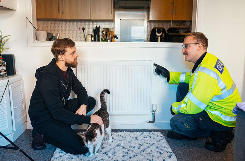 An engineer with a customer and pet in their home