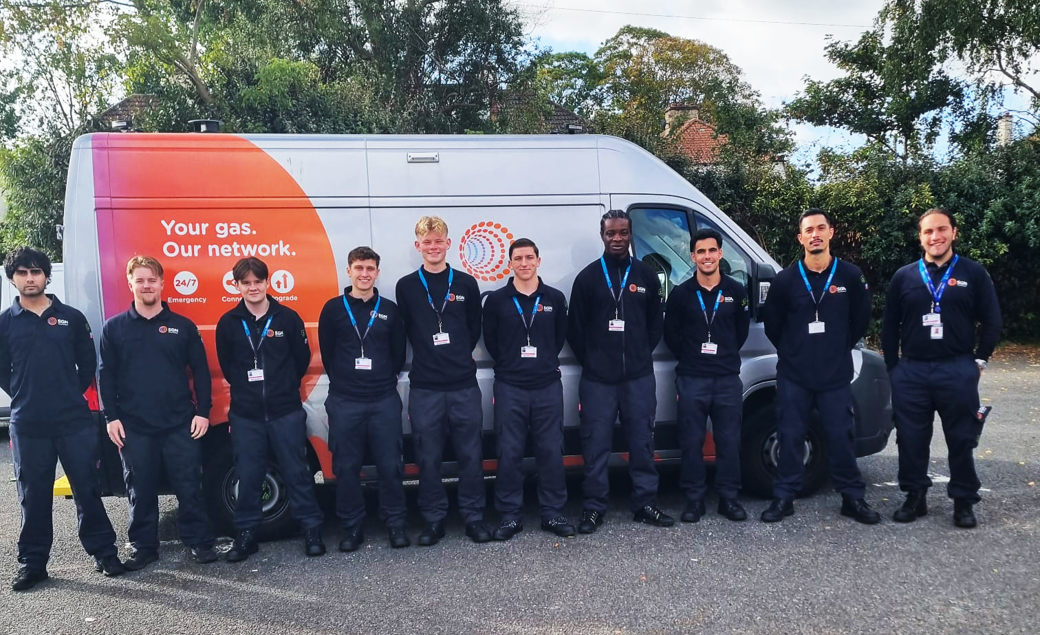 Ten young men in SGN PPE stood in front of an SGN van