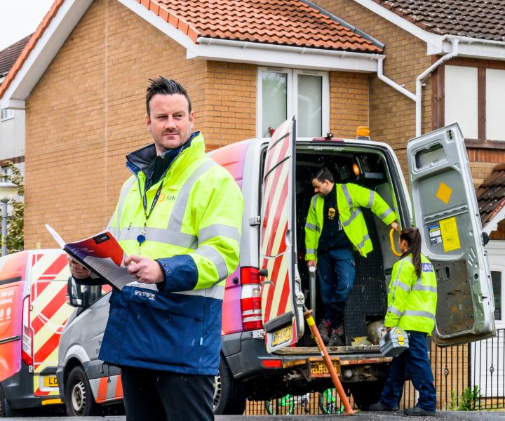 SGN engineers next to an SGN van on a residential street