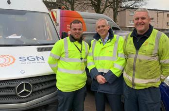 Three SGN colleagues wearing PPE and standing in front of an SGN van