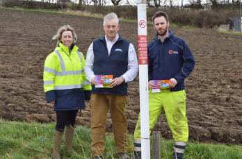 SGN colleagues with NFU Scotland partners standing in field next to pipeline location marker