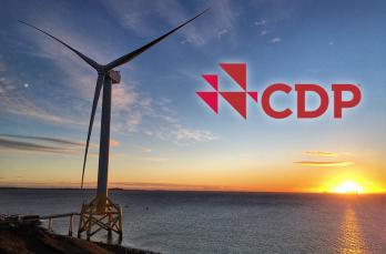 A wind turbine overlooking water at sunset. The CDP logo is also visible.