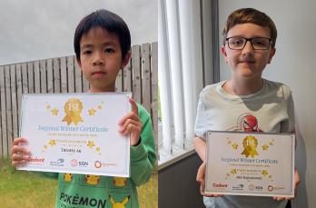 Two children holding their certificates for winning our carbon monoxide competition