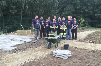 SGN team of volunteers pose for a picture at the site of landscape garden with equipment and new patio