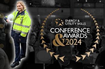 A woman in SGN PPE holding her protective helmet next to the logo for the Energy & Utility Skills Awards 2024
