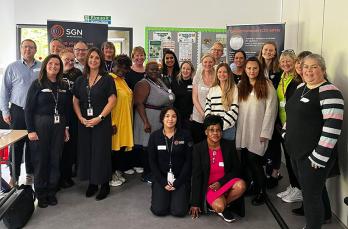 A large group of smiling people in front of SGN freestanding banners