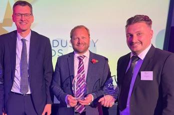 Three male colleagues from SGN standing in a row at the IGEM Awards ceremony 2025. Two are holding trophies