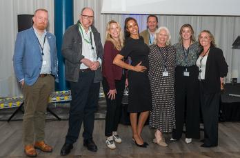 Eight men and women smiling to the camera, all chairs of SGN's employee networks