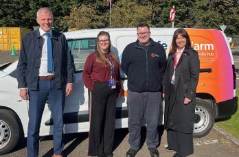 Two BSI auditors, one female and one male, stand in front of an SGN safe and warm van alongside two SGN colleagues (one male and one female). The weather is bright and all are smiling.