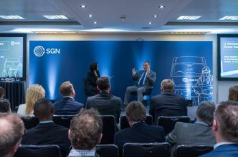 Minister for Energy Security and Net Zero Dr Alan Whitehead CBE and SGN's Abbie Sampson speak on stage in front of delegates at event dedicated to accelerating biomethane growth