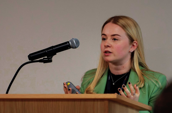 Woman wearing green suit behind lectern